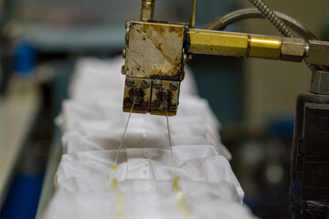 Production of independent springs for mattresses. Independent spring blocks packed in spunbond. Bonding layers of springs. Furniture manufacture. Industrial and business concept.