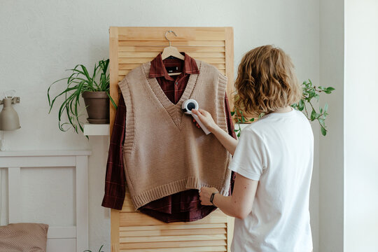 Woman removing lint from clothes