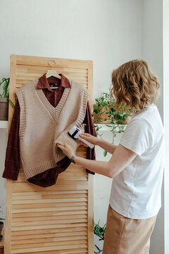 Woman removing lint from clothes