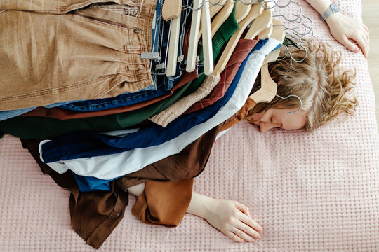 lying woman with pile of clothes on her back
