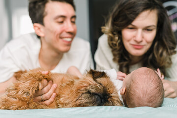 Couple with a dog and a baby on the bed