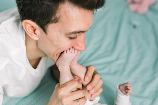 Man kissing his baby daughter's toes