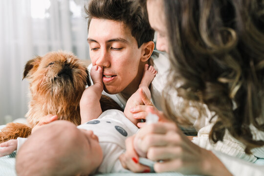 Family with a newborn and a Griffon dog