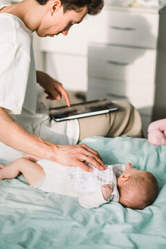 Father working while putting baby to sleep