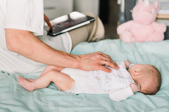 Man trying to put baby to sleep while working