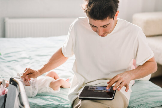 Young father working while caring for baby