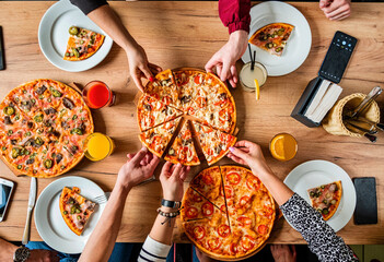 Group of people eating pizza.