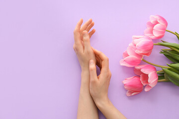 Female hands with flowers on color background