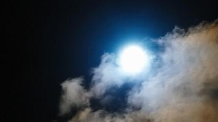 Naklejka na ściany i meble Blue Moon shines through night clouds