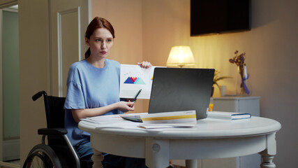 A disabled young woman is talking with someone and showing diagrams 