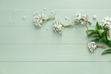 Beautiful gypsophila boutonnieres on color wooden background