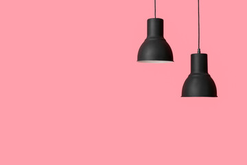 Black lamps hanging on pink background