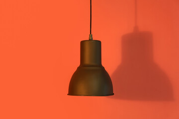 Obraz premium Black lamp hanging on red background