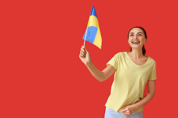 Happy young woman with Ukrainian flag on color background