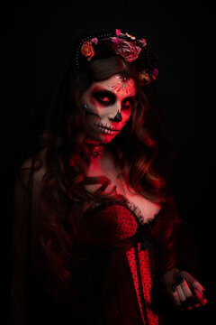 Beautiful Halloween Make-Up Style. Model Wear Sugar Skull Makeup with Red Roses. Santa Muerte concept