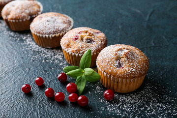 Delicious cranberry muffins on black background