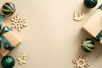 Christmas flat lay composition. Handcrafted gifts, wooden Christmas decorations, green balls on pastel beige background. Vintage Christmas greeting card design.