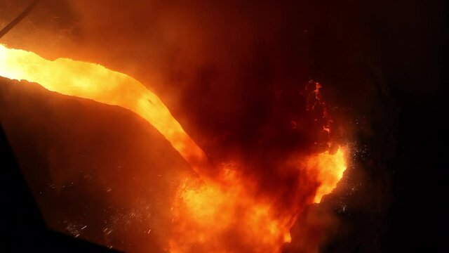 The process of melting metal with smoke and sparks. A stream of molten iron. Ferrous metallurgy. Iron smelting at a metallurgical plant. A fiery river of seething metal for steel production.