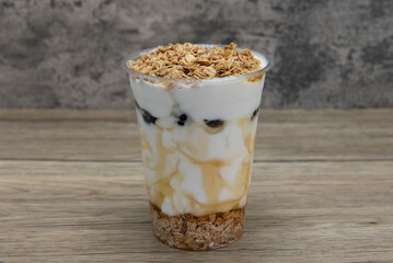 Yogurt parfait layered in a cup with fruit, oats, and nuts for a balanced breakfast on the go