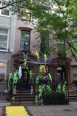 A townhouse with Halloween pumpkins and Halloween decorations in the evening on a city street.