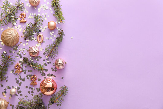 Composition with fir branches, Christmas decorations and confetti on lilac background, closeup