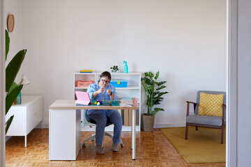Female artisan with Down syndrome working at home