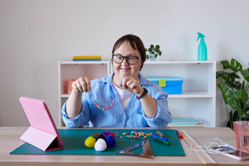 Happy artisan with Down syndrome showing beads