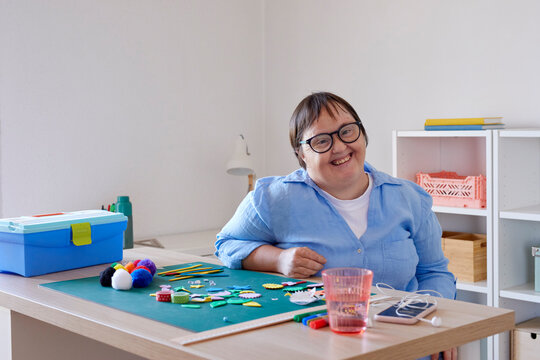 Optimistic craftswoman with Down syndrome taking break