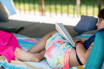 Crop teenager enjoying reading in summer