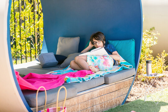 Teen reading book in cabin in yard