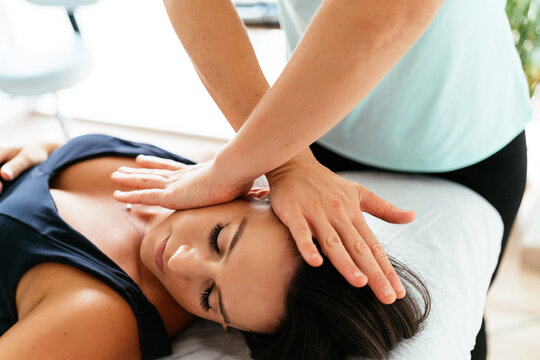 Masseuse treating woman in clinic