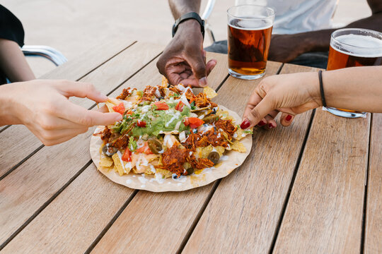 Anonymous diverse friends eating nachos