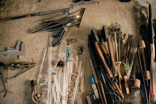 Top view of different tools and tubes of glassblowing on table