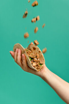 Hand holding Mexican pork tacos carnitas