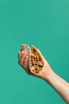 Hand holding Mexican pork tacos carnitas