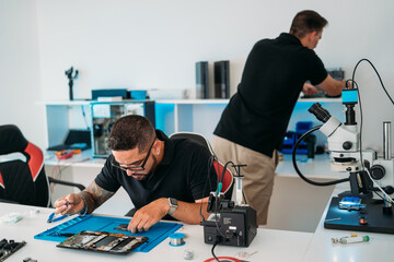 Men repairing mobile phones