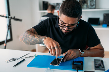 Focused technician screwing in cellphone parts