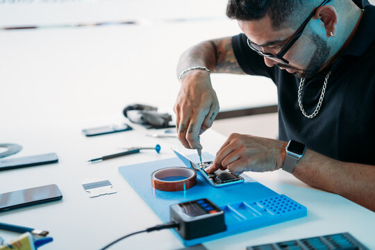 Man repairing cellphone on table