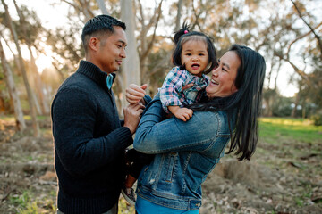 Asian parents holding toddler girl