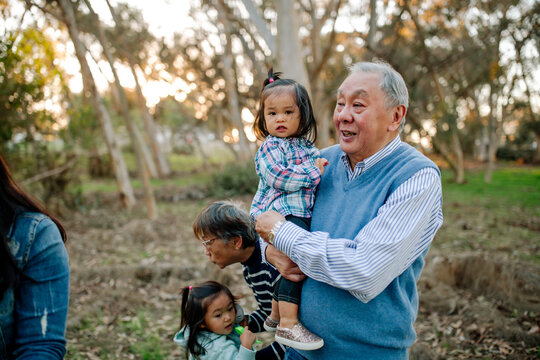 Asian grandfather holding granddaughter