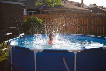 Young girl jumps into backyard pool and makes a big splash 