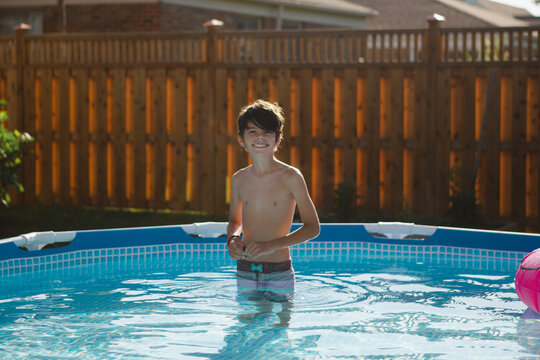 Portrait of happy boy in backyard pool 