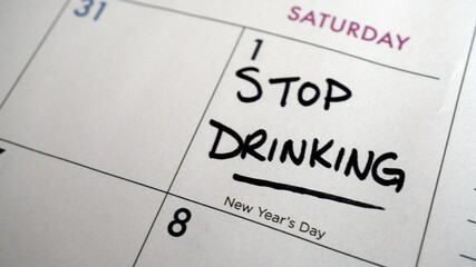 Reminder to  stop drinking written on a calendar on New Year's Day as a resolution or for the start of Dry January.