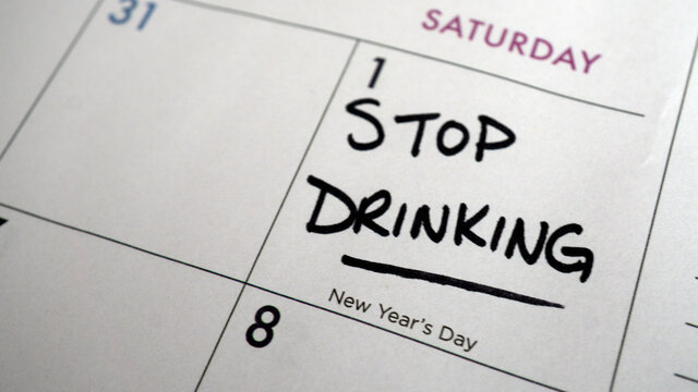 Reminder to stop drinking written on a calendar on New Year's Day as a resolution or for the start of Dry January. - Powered by Adobe