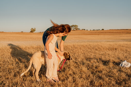Family caessing their doggy at field