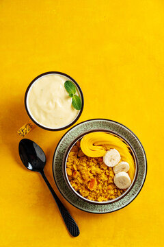 Cup of mango lassi and upma with mango on a table