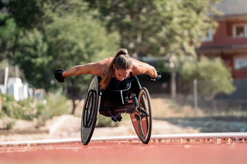 Female wheelchair athlete adjusting her chair on sports track