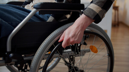 Fototapeta premium A disabled man is riding on the wheelchair through the room 