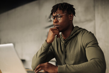 African man with laptop at the table. distance communication, training. online communication