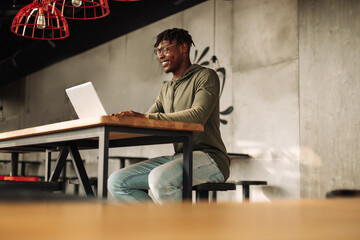 African man with laptop at the table. distance communication, training. online communication